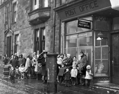 A queue of mothers and young children waiting for the Post Office to open, in Carmyle Glasgow.
