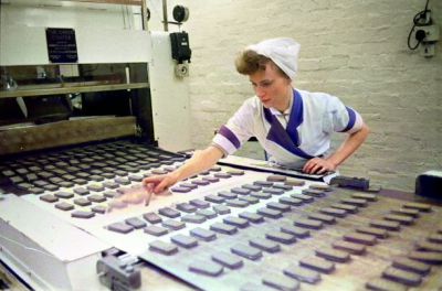 A worker checking the quality of biscuits on a conveyor belt in the Glengarry Bakery of William Macdonald and Sons, Glasgow 20th August 1955
