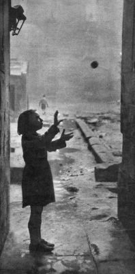 A young girl happily plays In a back court at a Gorbals slum
