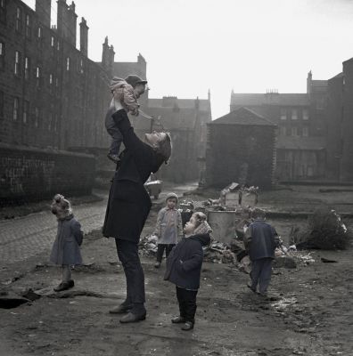 A youth worker plays with children in the Gorbals district of Glasgow, January 1966
